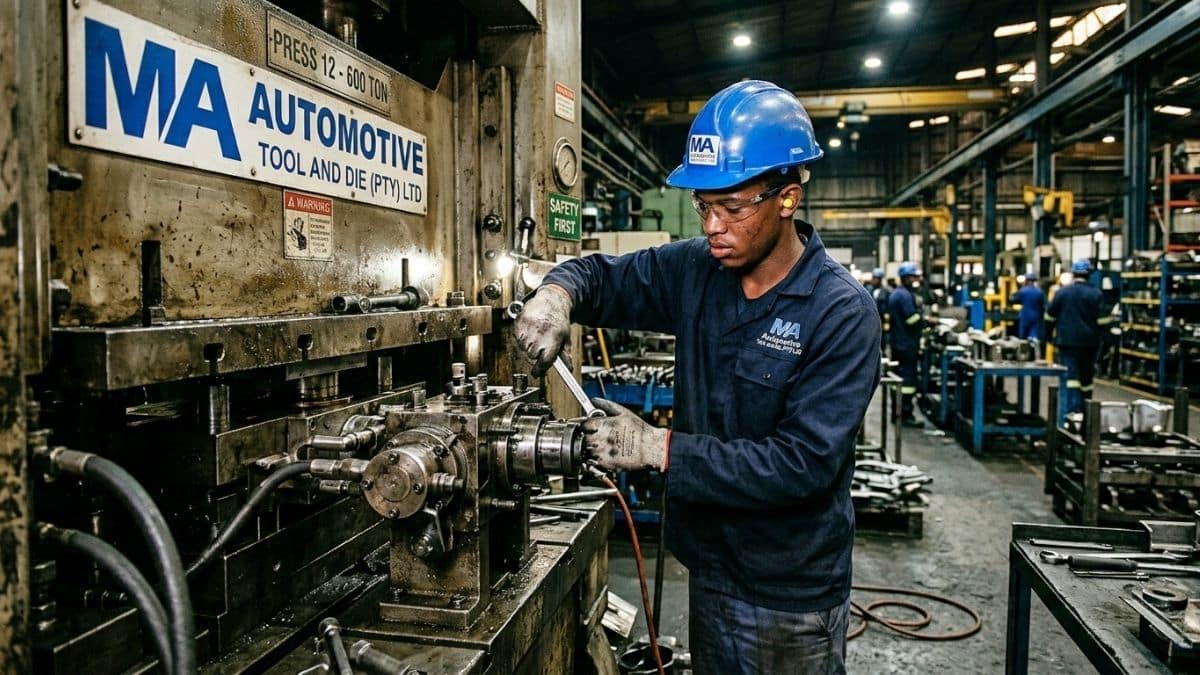 Millwright apprentice working on machinery in automotive factory